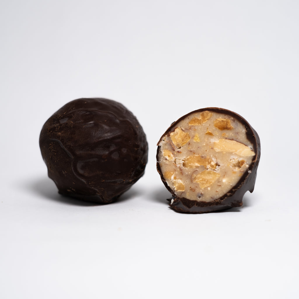 Baci Strega: deliziose praline artigianali di ricoperte di cioccolato e ripiene di cioccolato bianco e gustose mandorle tostate aromatizzate al liquore strega.